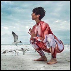 woman doing yoga pose on beach with seagulls behind her