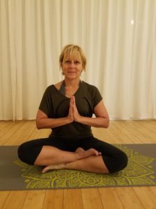 woman sitting on yoga mat in meditation pose