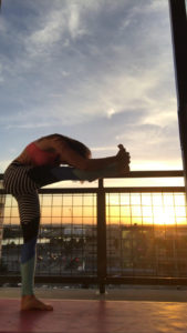 woman stretching leg on balcony railing