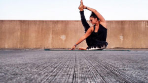 woman doing yoga pose, wall behind her