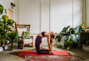 woman doing yoga pose in room with plants