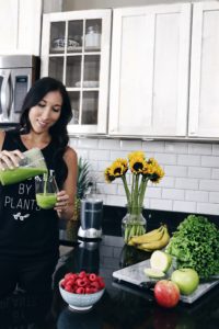 woman pouring green juice into cup