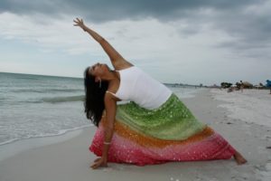 woman doing yoga pose on a beach