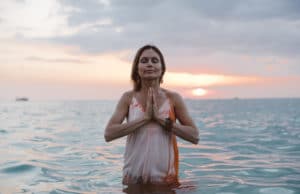 woman doing yoga pose in the ocean