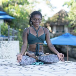 woman smiling with legs crossed doing yoga pose meditating