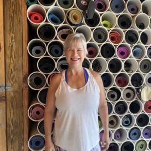 cheerful woman in front of yoga mats