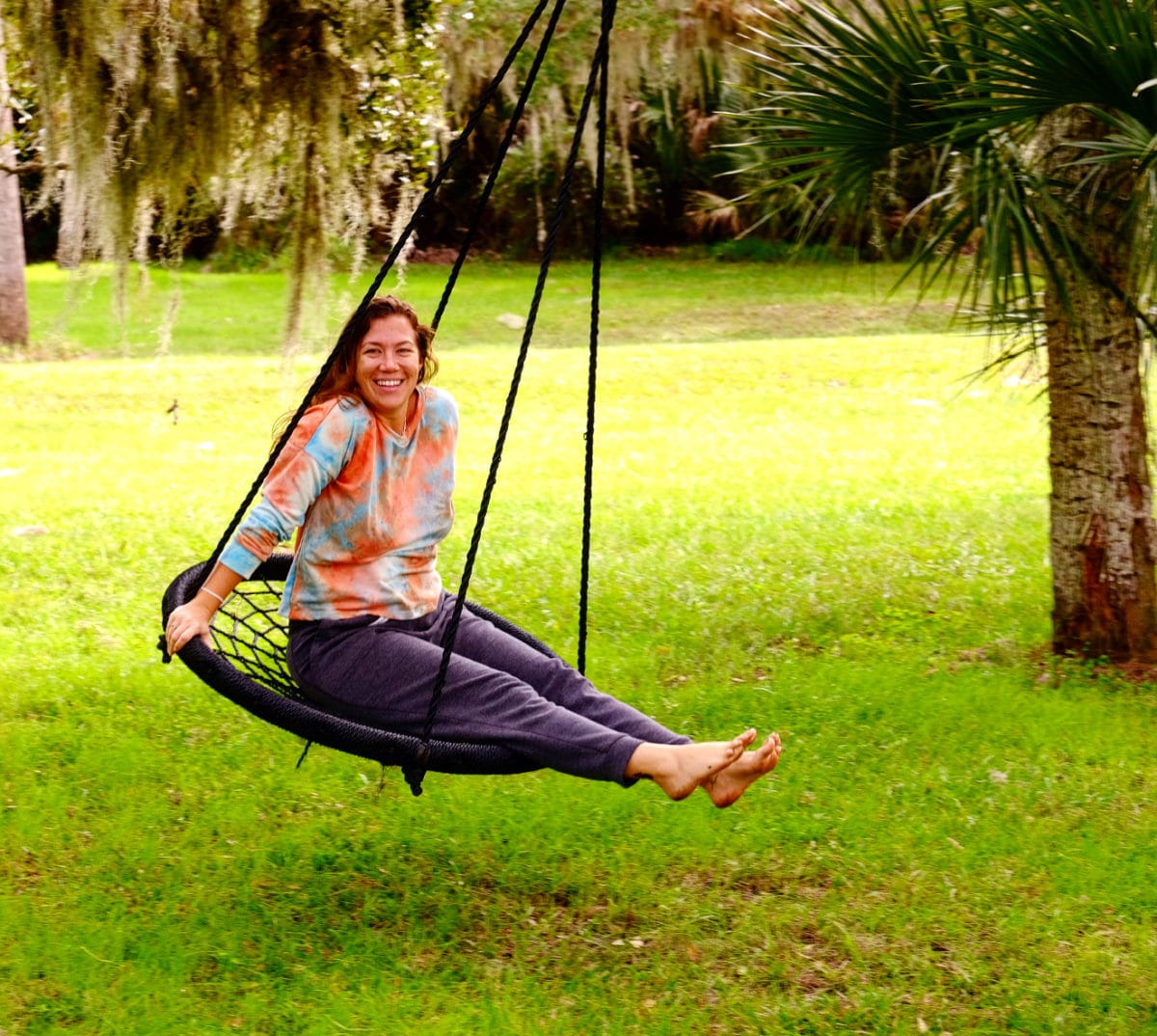 Woman smiling and swinging outside.